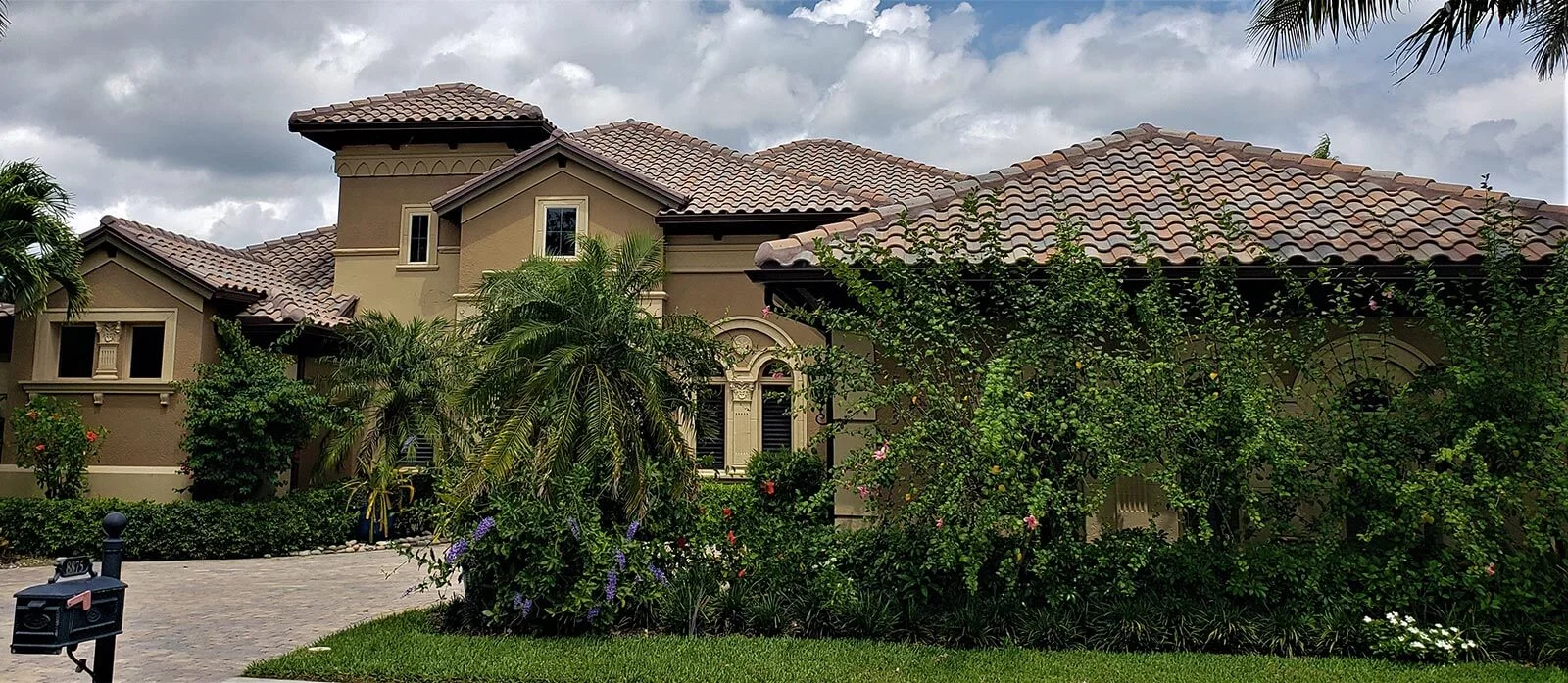 Tile roof home behind a hedge