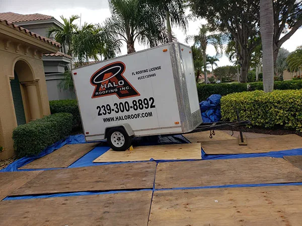 Halo Roofing trailer on a job site with the driveway covered